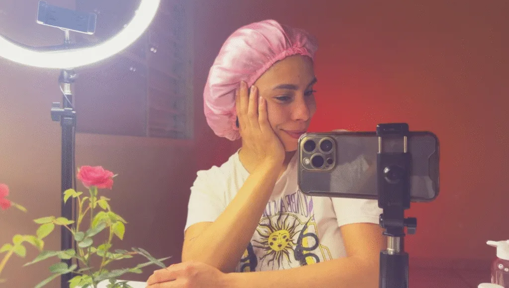 Mulher usando touca de cetim — proteção noturna para reduzir o frizz, manter a hidratação e preservar a definição dos cabelos durante o sono.